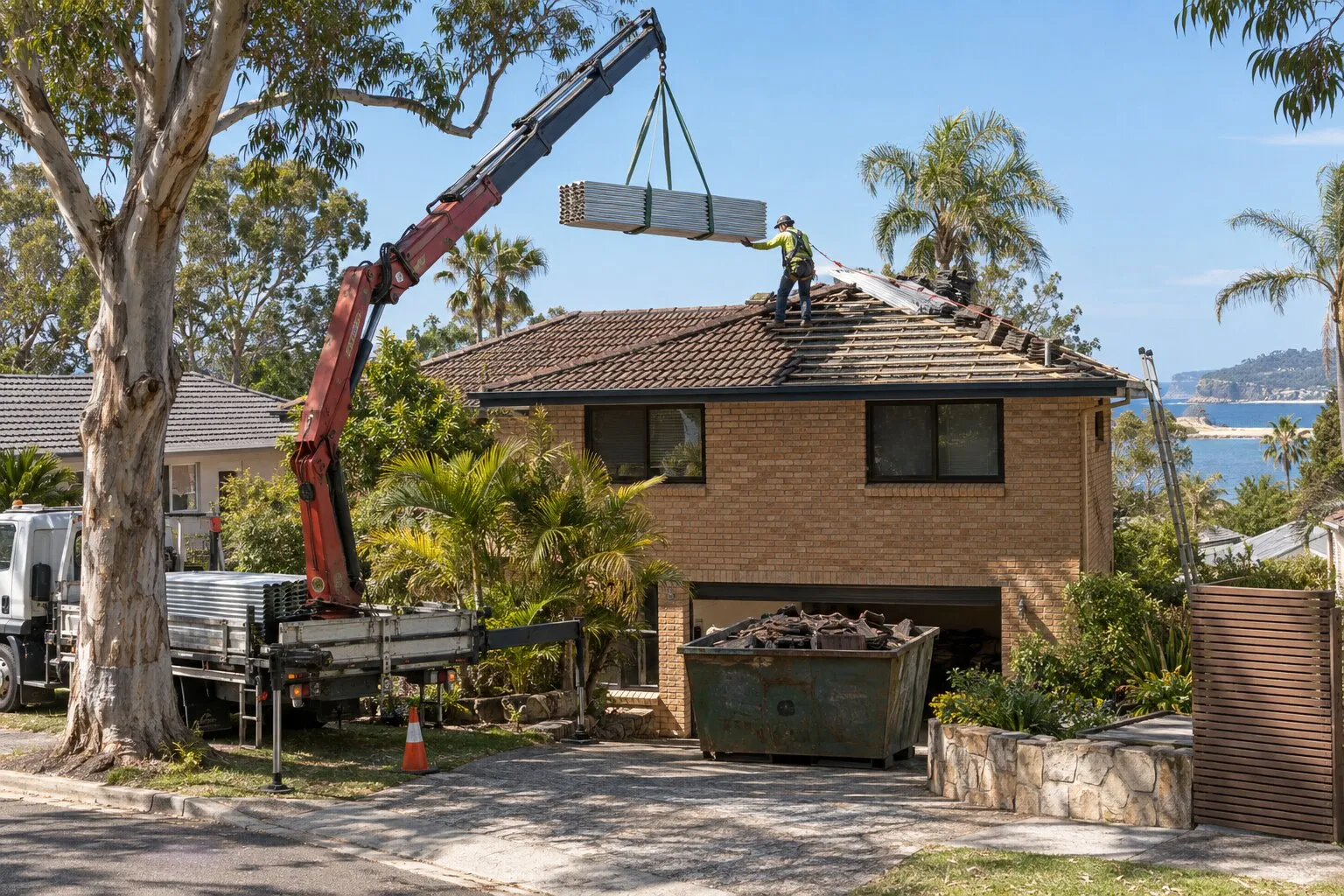Roof replacement cost, Northern Beaches: crane lifting new Colorbond sheets onto a two-storey brick home being re-roofed