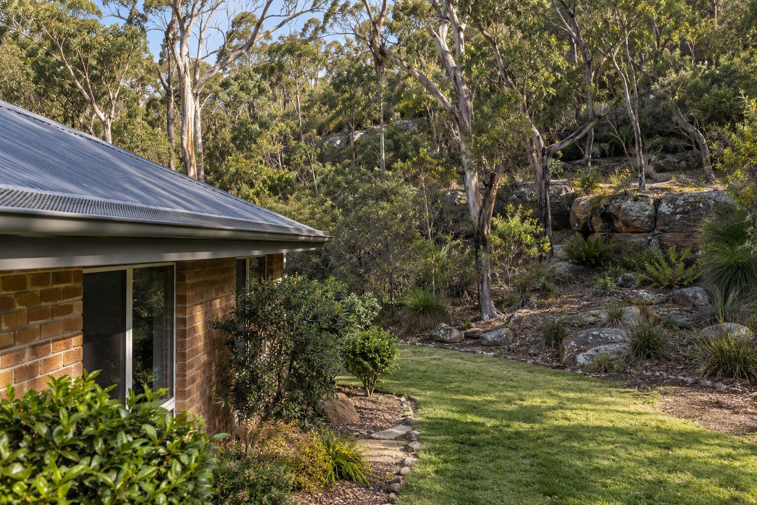 Roofing, Belrose: brick home on the edge of sandstone bushland with a Colorbond roof and metal gutter guard